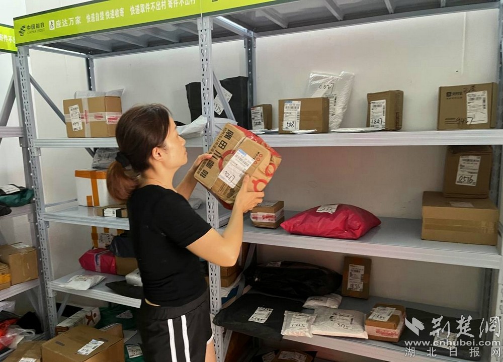 在城北街道西十村寄遞物流綜合便民服務(wù)站，站點負責人正在對快遞包裹進行分類擺放  攝 余新怡攝.jpg